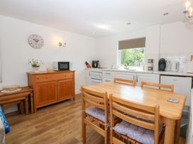 A kitchen with a table and chairs at Hafan Bach in Abersoch
