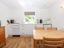 A kitchen with a table and chairs at Hafan Bach in Abersoch