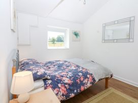 A bedroom with a bed and lamp at Hafan Bach in Abersoch