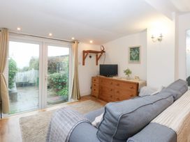 A snug room with a sofa and television at Hafan Bach in Bwlchtocyn near Abersoch