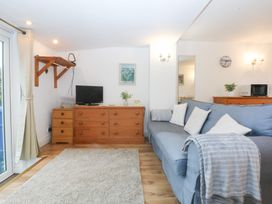 A living room with a couch and a television at Hafan Bach Bwlchtocyn near Abersoch