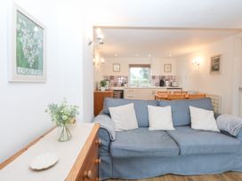A living room with a sofa and kitchen area at Hafan Bach in Bwlchtocyn near Abersoch