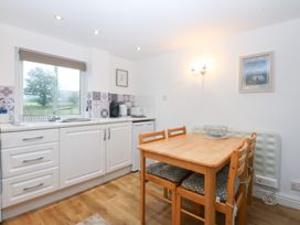 A kitchen with a table and chairs at Hafan Bach in Bwlchtocyn near Abersoch