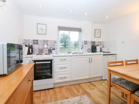 A kitchen with appliances and dining table at Hafan Bach Bwlchtocyn near Abersoch