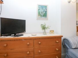 A living room with a television and drawers at Hafan Bach in Bwlchtocyn near Abersoch