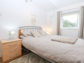 A bedroom with a bed and bedside table at Hafan Bach in Bwlchtocyn near Abersoch