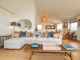 A living room with a sectional sofa and coffee table at 8 Karn Havos in St. Eval near Mawgan Porth