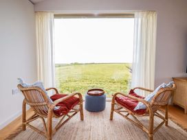 A sitting room with two chairs and a table at 8 Karn Havos St. Eval near Mawgan Porth