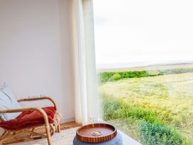 A seating area with a chair and tray at 8 Karn Havos St. Eval near Mawgan Porth