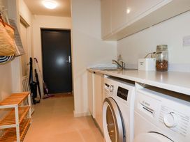 A laundry room with a washing machine, dryer, and sink at 8 Karn Havos in St. Eval near Mawgan Porth