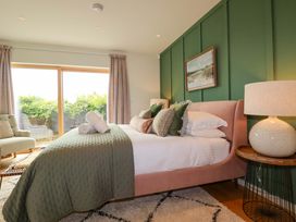 A bedroom with a bed and a chair at 8 Karn Havos St. Eval near Mawgan Porth