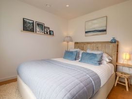 A bedroom with a bed and bedside table at 8 Karn Havos St. Eval near Mawgan Porth
