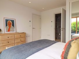 A bedroom with a bed and artwork on the wall at 8 Karn Havos in St. Eval near Mawgan Porth