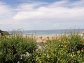 A view of the sea and sand from a grassy area at 8 Karn Havos St. Eval near Mawgan Porth