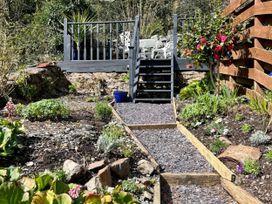 A garden with stairs leading to a deck at Copper Miners Cottage, Beddgelert, Eryri (snowdonia)