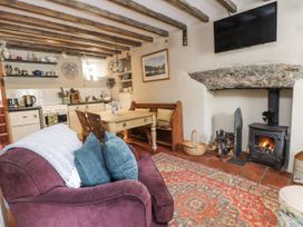 A living room with a sofa, table, and fireplace at Copper Miners Cottage, Beddgelert, Eryri (snowdonia)