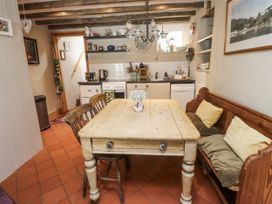 A kitchen with a table and chairs at Copper Miners Cottage, Beddgelert, Eryri (snowdonia)