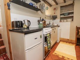A kitchen with an oven, fridge, kettle, and utensils at Copper Miners Cottage in Beddgelert, Eryri (snowdonia)