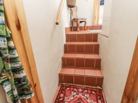 A staircase with a rug and chair at Copper Miners Cottage in Beddgelert, Eryri (snowdonia)