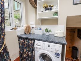 A utility room with a washing machine and counter at Copper Miners Cottage, Beddgelert, Eryri (snowdonia)