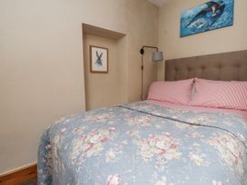 A bedroom with a bed and wall art at Copper Miners Cottage, Beddgelert, Eryri (snowdonia)