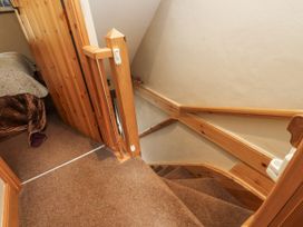 Staircase with wooden handrail and door at Copper Miners Cottage, Beddgelert, Eryri (snowdonia)