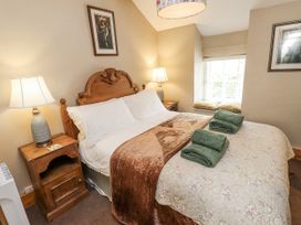 A bedroom with a bed and bedside lamp at Copper Miners Cottage in Beddgelert, Eryri (snowdonia)