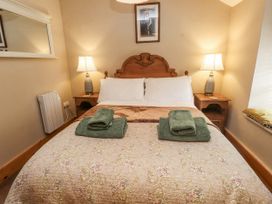 A bedroom with a bed and bedside tables at Copper Miners Cottage, Beddgelert, Eryri (snowdonia)