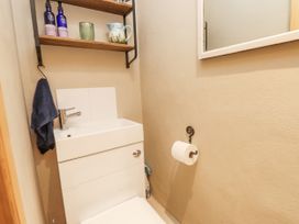 A bathroom with a sink and shelf at Copper Miners Cottage Beddgelert, Eryri (snowdonia)