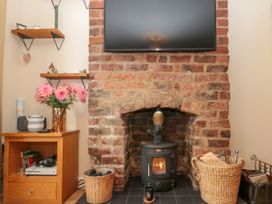 A living room with a wood stove and television at No.64 Nelson St in Bridlington