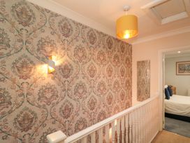 A hallway with wallpaper and a mirror at No.64 Nelson St, Bridlington