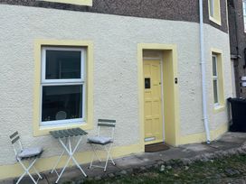 A doorway and window with outdoor seating at Sun House in Allonby