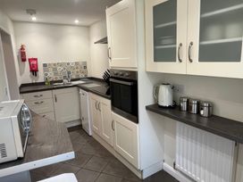 A kitchen with microwave, oven, kettle, and sink at Sun House in Allonby