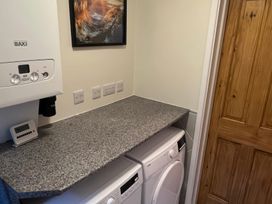 A laundry room with a washing machine and a boiler at Sun House in Allonby