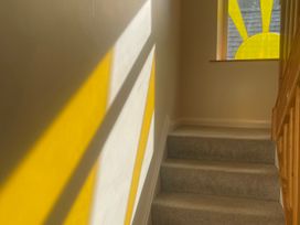 A staircase with sunlight coming through a window at Sun House in Allonby