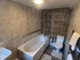 A bathroom with a bathtub, toilet, and sink at Sun House in Allonby