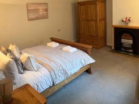 A bedroom with a bed, wardrobe, and fireplace at Sun House in Allonby