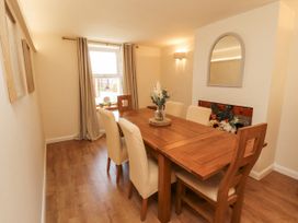 A dining room with a wooden table and chairs at Sun House in Allonby