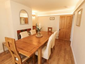 A dining room with a wooden table and chairs at Sun House in Allonby