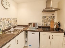 A kitchen with a sink and microwave at Sun House in Allonby