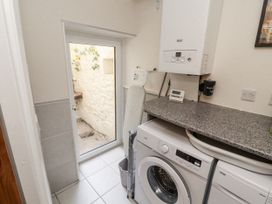 A laundry room with a washing machine and a boiler at Sun House in Allonby