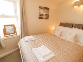 A bedroom with a bed and mirror at Sun House in Allonby