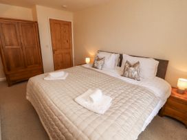 A bedroom with a bed and wardrobe at Sun House in Allonby