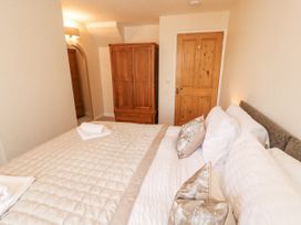 A bedroom with a bed and wardrobe at Sun House in Allonby