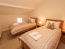 A bedroom with two beds and a window at Sun House in Allonby