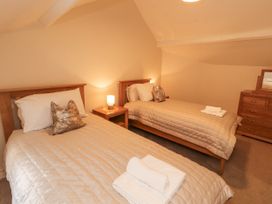 A bedroom with two beds and a dresser at Sun House in Allonby