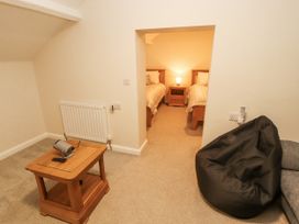 A bedroom with two beds and a bean bag at Sun House in Allonby