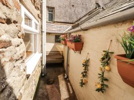 An outdoor area with a stone wall and planters at Sun House in Allonby