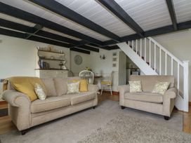 A living room with sofa and armchair at Driftwood Cottage in St. Austell