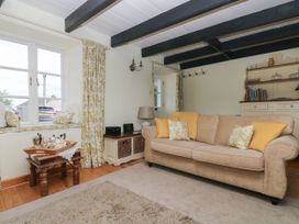 A living room with a sofa and coffee table at Driftwood Cottage in St. Austell